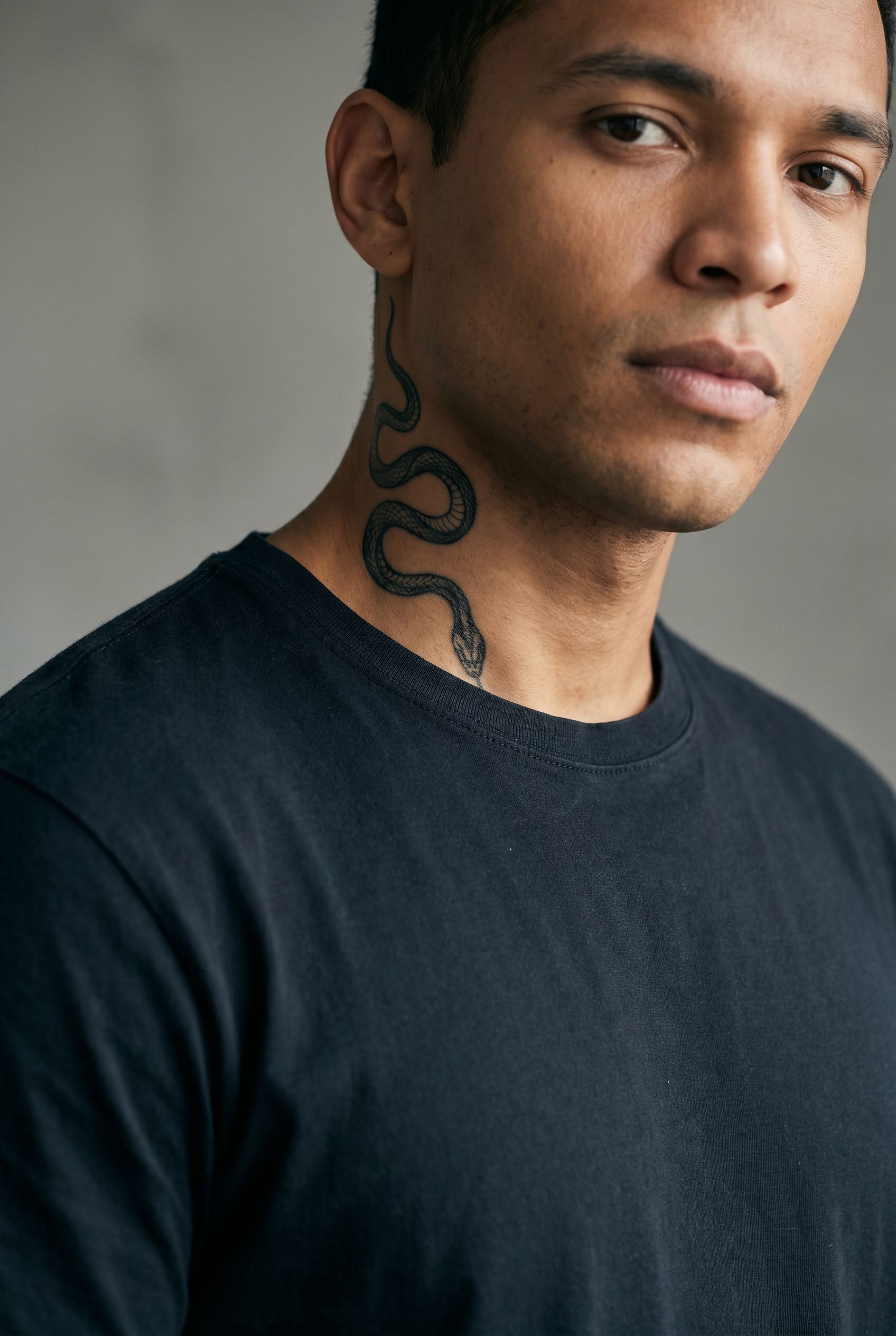 Tatouage serpent descendant le long du cou d'un homme