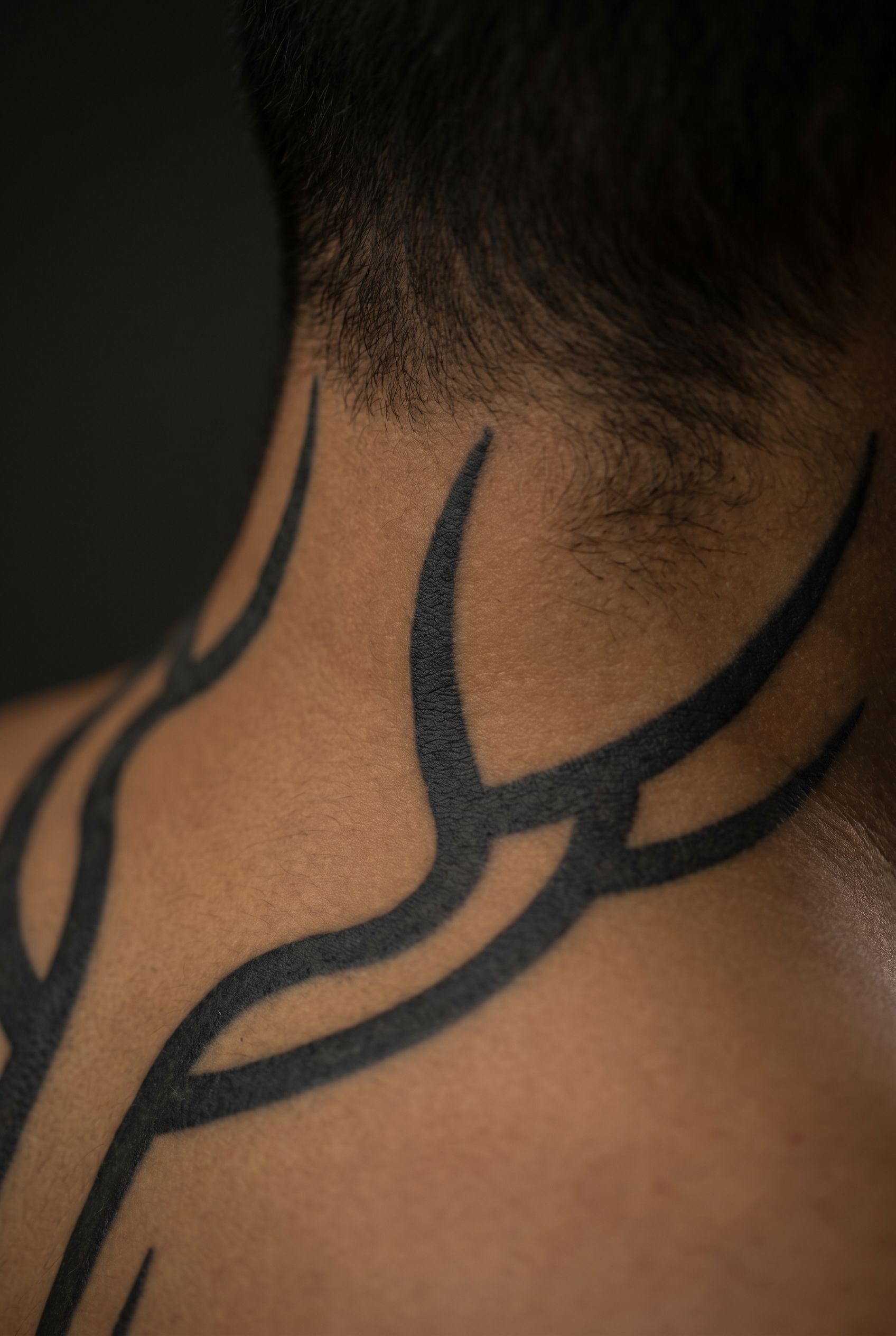 Tatouage tribal blackwork sur la nuque d'un homme