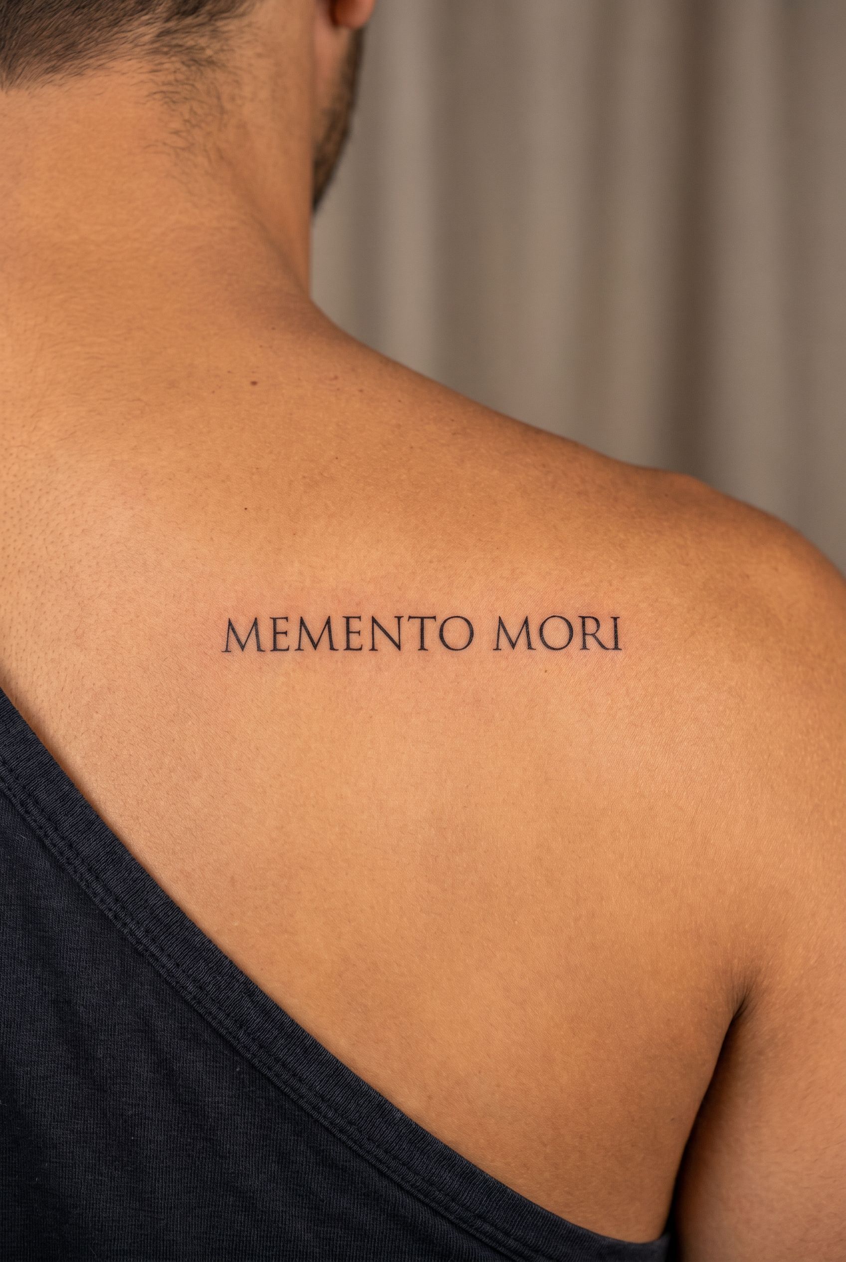 Tatouage de la phrase latine Memento mori sur l'avant-bras