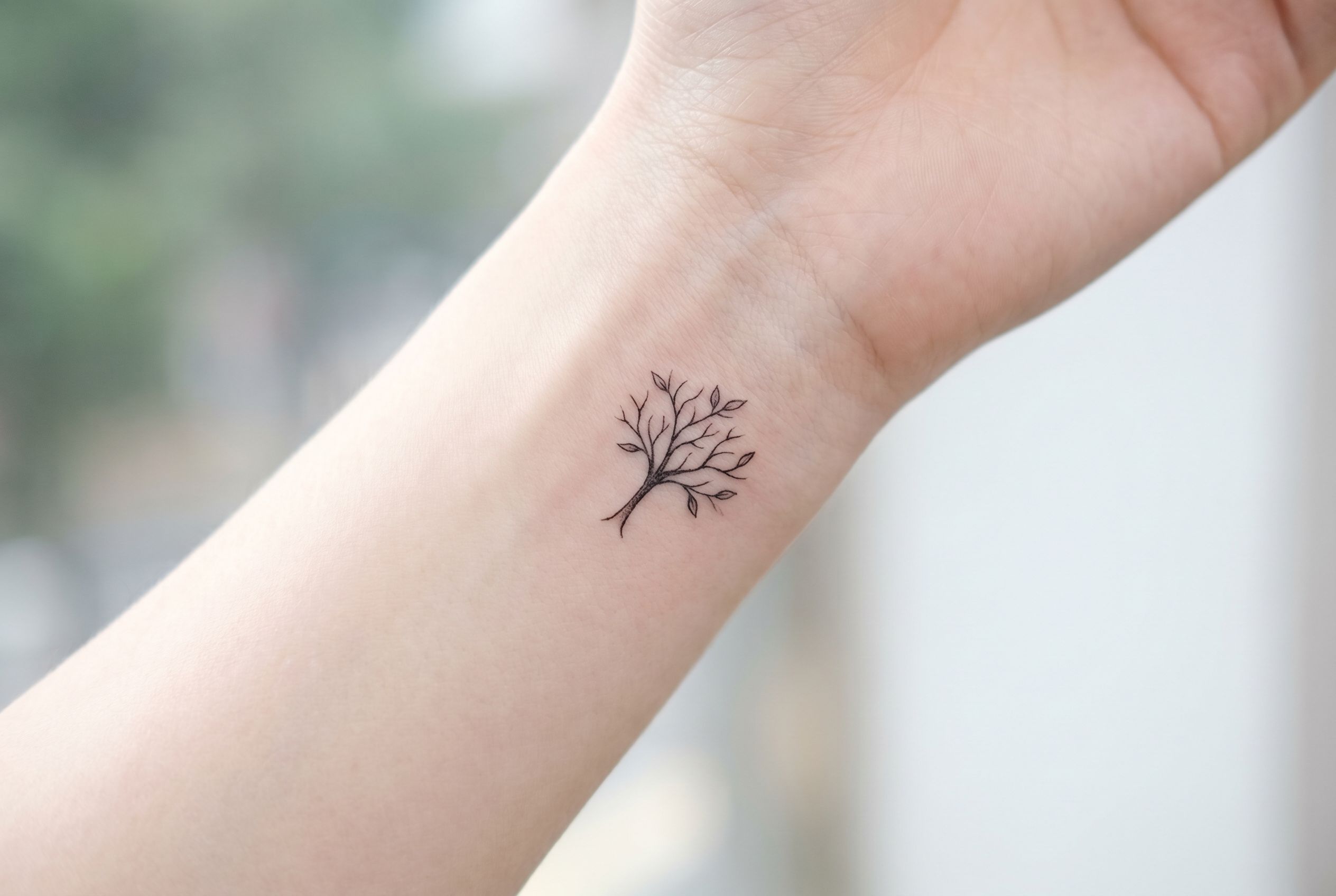 Tatouage arbre minimaliste fine ligne sur le poignet
