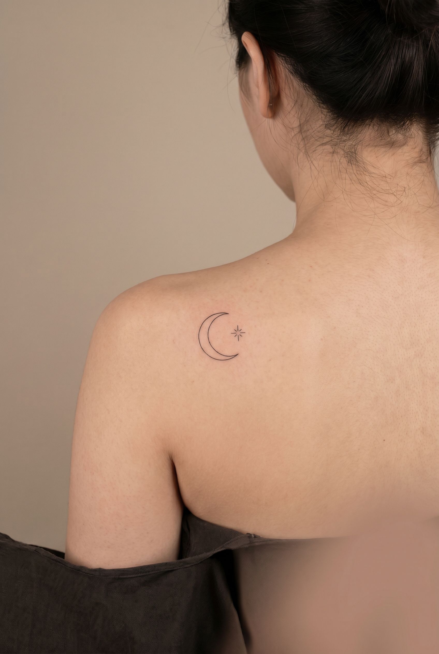Petits symboles minimalistes croissant de lune et etoile tatoues sur l'omoplate